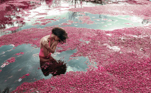 Woman swimming in lake with petals