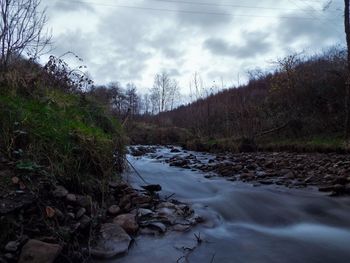 Scenic view of river against cloudy sky