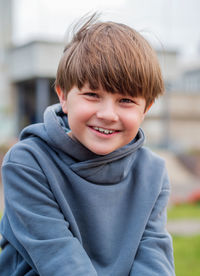 Cute caucasian boy wearing casual is sitting on the schoolyard