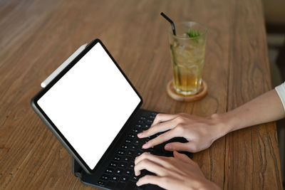 Midsection of man using mobile phone on table