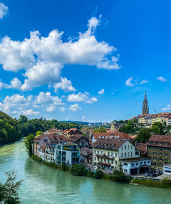 River amidst buildings against blue sky