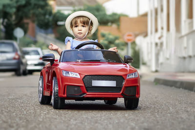 A girl riding a toy car