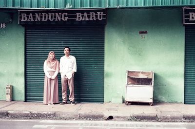 Full length of friends standing on entrance of building