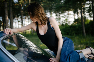 Young woman is resting on vintage car