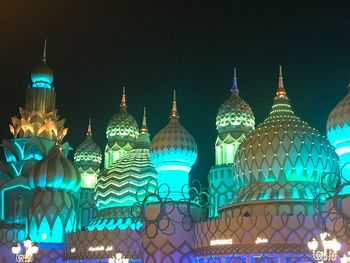 Low angle view of illuminated buildings against sky at night