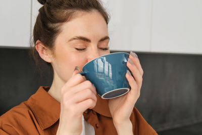 Young woman drinking coffee at home