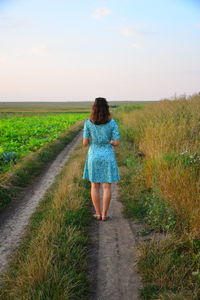 Rear view of man walking on field