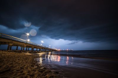 View of bridge over sea against sky at night