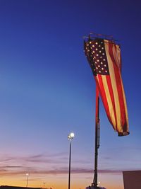 Low angle view of flag against blue sky