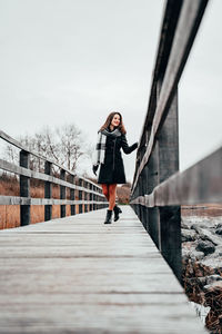 Full length of woman standing on footbridge