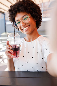 Portrait of smiling woman drinking in cafe