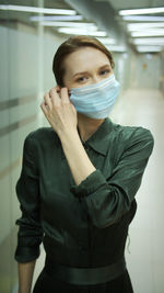 Smiling woman wearing surgical mask at office