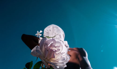 Close-up of woman against blue sky