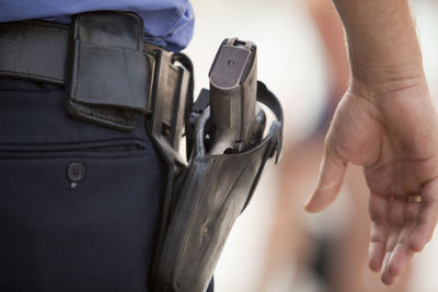 Midsection of man with handgun standing outdoors