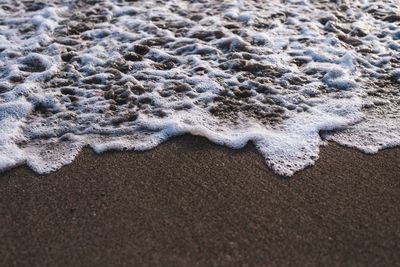 High angle view of waves on sand at beach