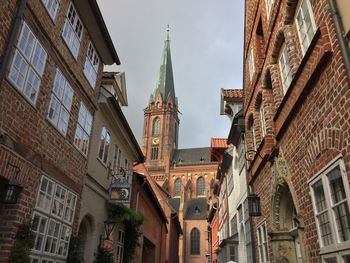 Low angle view of clock tower in city against sky