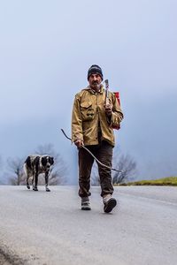 Man with dog walking on road