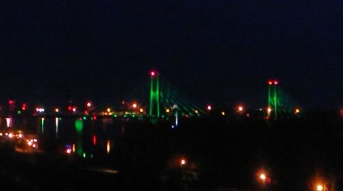 Illuminated city against sky at night