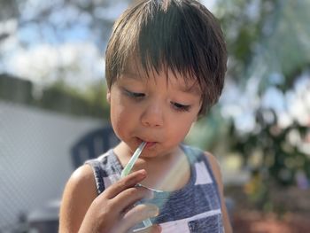 Close-up of boy drinking mango juice