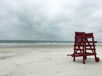 Lifeguard hut on beach against sky