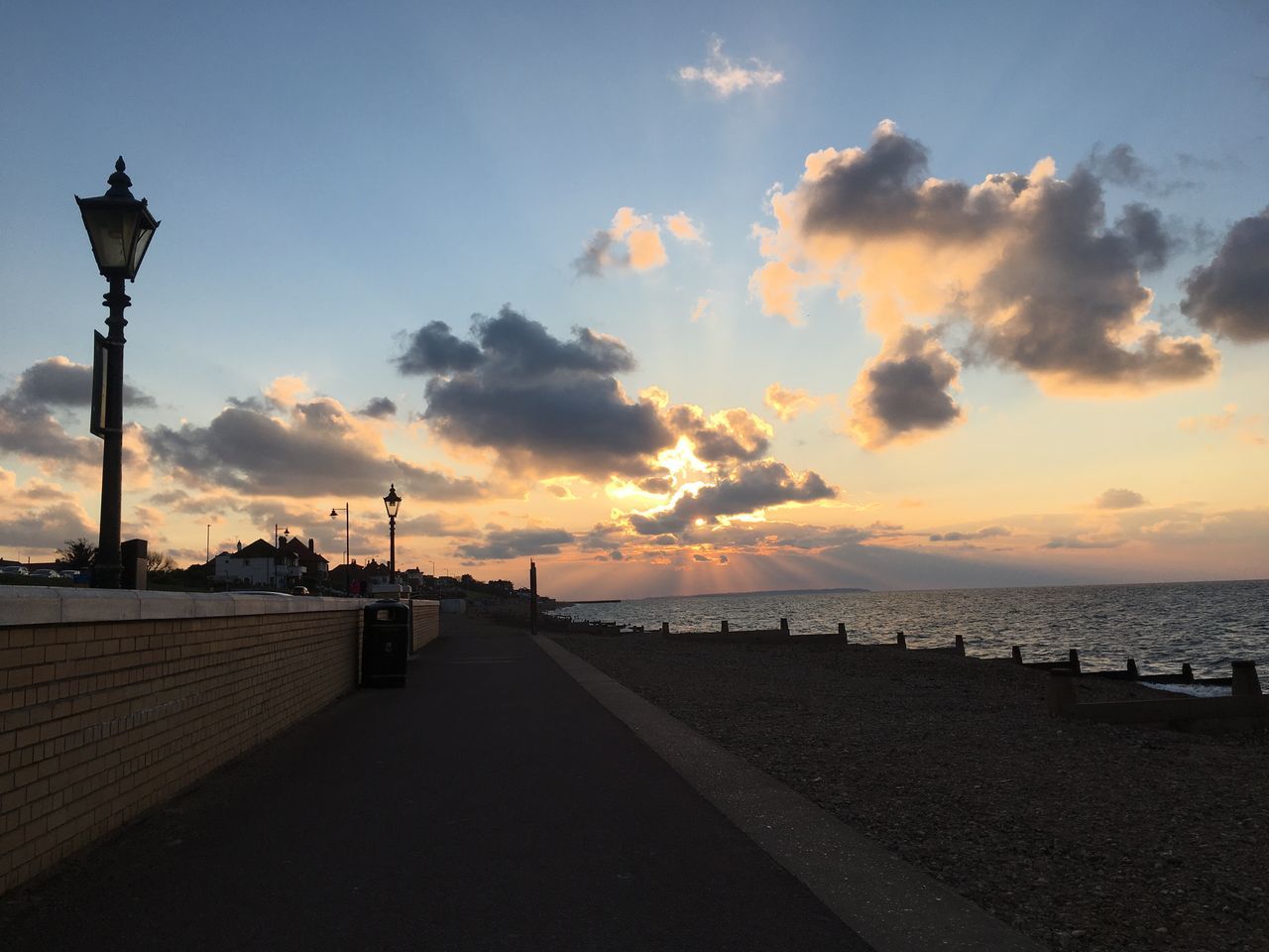 sky, sunset, cloud - sky, water, beauty in nature, sea, street, street light, scenics - nature, nature, architecture, direction, lighting equipment, built structure, the way forward, no people, footpath, tranquil scene, tranquility, outdoors, horizon over water, promenade