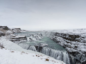 Scenic view of waterfall gullfoss against sky during winter