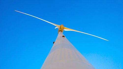 Low angle view of windmill against clear blue sky