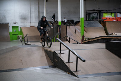 Man riding bicycle on railing