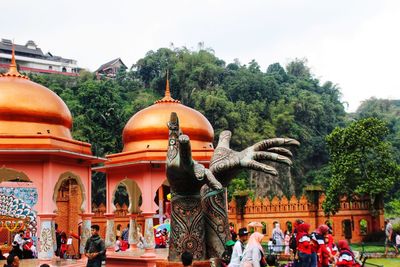 Statue by historic building against sky