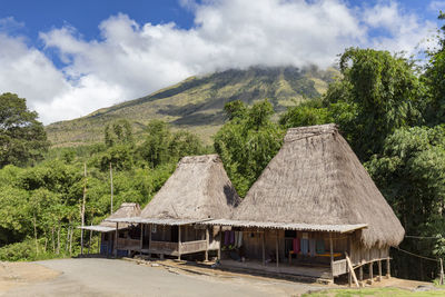 Built structure by trees on mountain against sky