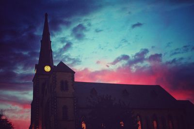 Silhouette of clock tower against sky at sunset