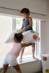 Rear view of siblings standing in corridor