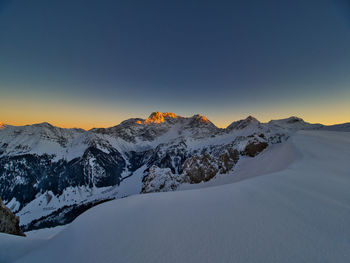 Scenic view of snowcapped mountains against sky during sunset