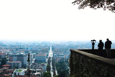 People looking at cityscape against sky