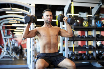 A man doing shoulder exercises at the gym.