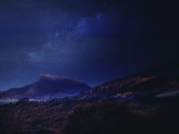 Scenic view of mountains against sky at night