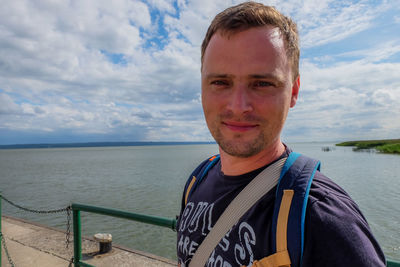 Portrait of smiling man in sea against sky