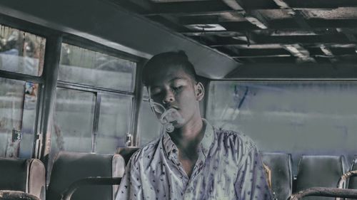 Portrait of young man sitting in bus