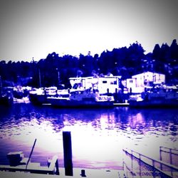 Boats in harbor against clear sky