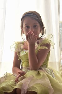 Portrait of a girl sitting on bed at home