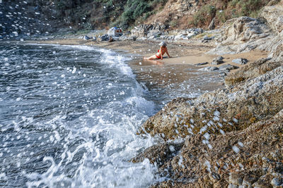 Rear view of man surfing in sea