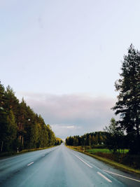 Road amidst trees against sky