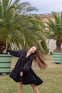 Full length of young woman with palm tree