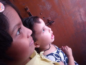 Side view of siblings looking away at home