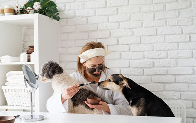 Self care. young caucasian woman wearing bathrobes doing spa procedures with her dog