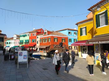 People walking on street against buildings in city