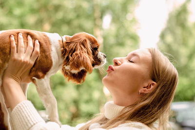 Close-up of woman with eyes closed holding dog