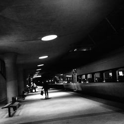 Woman walking in illuminated tunnel