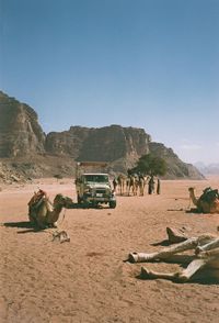 People on dirt road against clear sky