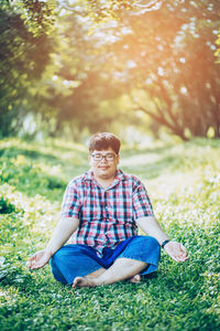 Full length of young man sitting on field